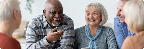 Group of older adults gathered around a table, sharing conversation and enjoying time together.