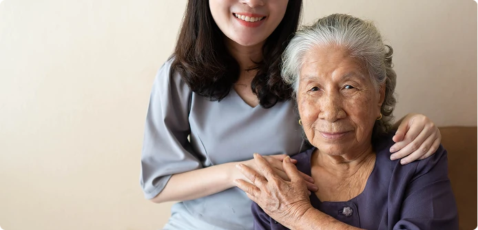 Caregiver gently embracing an elderly woman, offering comfort and support at home.